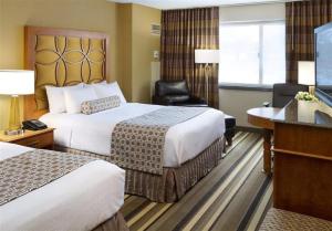 um quarto de hotel com duas camas e uma secretária em Crowne Plaza Minneapolis West, an IHG Hotel em Plymouth