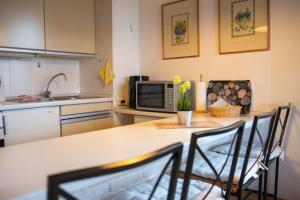 a kitchen with a table with chairs and a microwave at Haus am Deich Wohnung 1 in Dahme