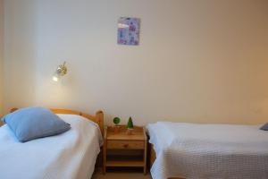 a bedroom with two beds and a table with a picture on the wall at Haus am Deich Wohnung 1 in Dahme