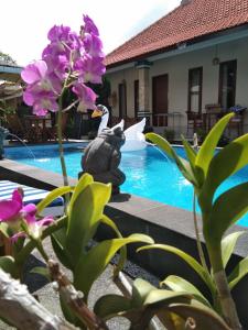 uma estátua de um coelho ao lado de uma piscina em SunwuKong Guest House em Ubud