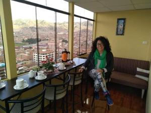 una mujer sentada en una mesa en un restaurante en Casa Hospedaje Killari en Cusco