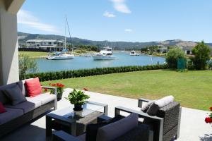 a patio with couches and a view of a harbor at Casa Aquila in Whitianga