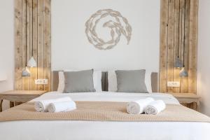 a bed with a white comforter and pillows at Joanna Villas in Kamari