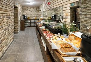 HOTEL LUBLIN في لوبلين: طابور بوفيه مع الخبز والمعجنات في مطبخ
