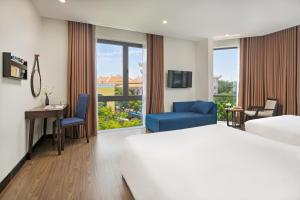 a hotel room with a bed and a desk and chair at Haka Boutique Hotel in Da Nang +74 photos