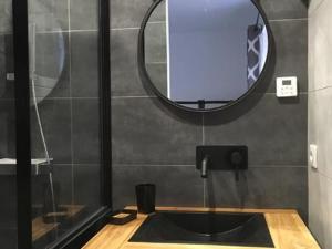 a bathroom with a black sink and a mirror at Les Terrasses du Donon in Raon-lès-Leau