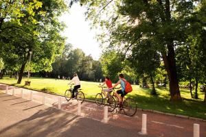 two people riding bikes down a street in a park at City Large Studio in Limassol