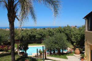 a palm tree and a swimming pool with the ocean in the background at Villa Palma in Maleme