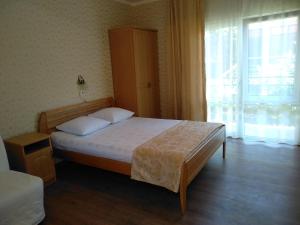 1 dormitorio con cama y ventana grande en Hotel Breez, en Lazarevskoye