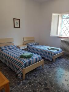 een kamer met twee bedden en een raam bij Villa Frida in Campomarino