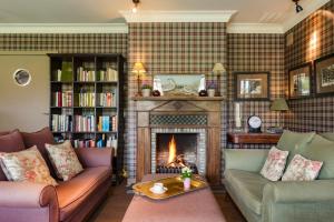 a living room with two couches and a fireplace at Country House Duinhof in De Haan
