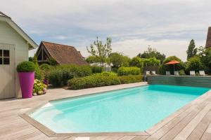 a swimming pool in the backyard of a house at Country House Duinhof in De Haan