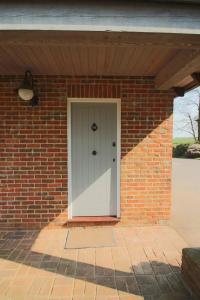 a brick house with a white front door at Little Wisteria in Canterbury