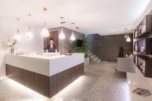 a woman standing at a reception desk in a room at Ntinas Filoxenia Hotel & Spa in Skala Potamias