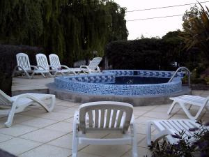 a group of chairs sitting around a swimming pool at Complejo Tehuelches in Puerto Madryn