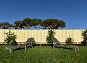 twee stoelen en een tafel in het gras bij Lake Tyrrell Accommodation LTA in Sea Lake