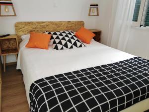 a bedroom with a black and white bed with orange pillows at Lilliput Studio Corfu Old Town in Corfu Town
