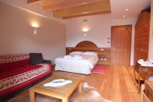 a hotel room with a bed and a couch at Albergo Edelweiss - LareSpa in Crodo