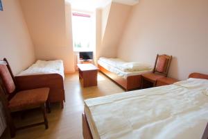 a room with two beds and chairs and a window at Wisełka PERŁA Bałtyku in Wisełka