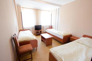 Zimmer mit 2 Betten, einem Stuhl und einem TV in der Unterkunft Wisełka PERŁA Bałtyku in Wisełka