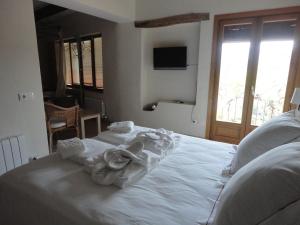 a bedroom with a white bed with towels on it at Hotel Rural Cal Torner Adults Only in Guiamets