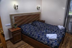 a bedroom with a bed with a blue comforter at Lara Hotel in Goris