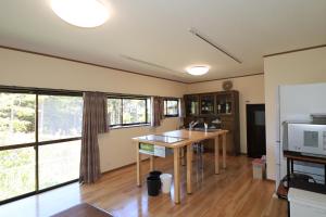 a kitchen with a table and some windows at The M NAKATSUGAWA in Nakatsugawa
