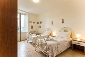 a bedroom with two beds and a window at Centro Storico Carlo Alberto in Alghero