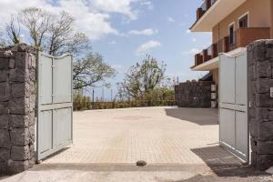 een open poort naar een gebouw met een oprit bij Villa Ginevra in Santa Venerina
