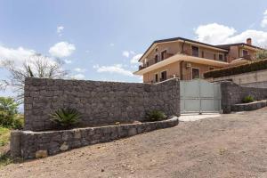 a stone retaining wall in front of a house at Villa Ginevra in Santa Venerina