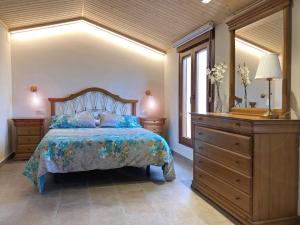 1 dormitorio con 1 cama con tocador y espejo en Camí de la Font, en Cretas