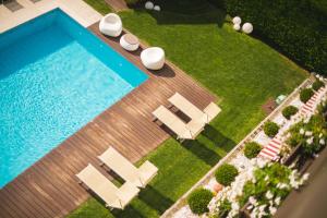 an overhead view of a swimming pool with chaise lounges and lounge chairs at Apartmenthotel Ritterhof Suites & Breakfast in Schenna