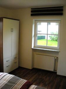 1 dormitorio con ventana, 1 cama y vestidor en Easyapartments Countryside, en Salzburgo