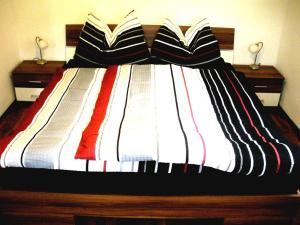 a bed with striped blankets and pillows on it at Easyapartments Countryside in Salzburg