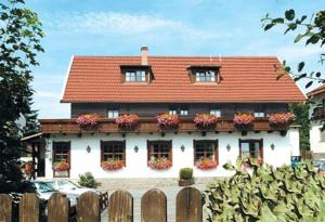 a house with a red roof with flower boxes on it at Pension Zum Rechen in Bodenmais