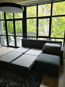 a couch in a room with large windows at Loft on Owl Hill in Kaunas