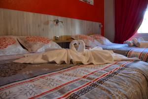 dos cisnes están sentados encima de dos camas en Hotel des Remparts, en Villeneuve-sur-Lot