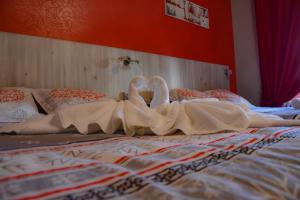 two swans made out of sheets on a bed at Hotel des Remparts in Villeneuve-sur-Lot