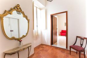 a hallway with a mirror and a red couch at Centro Storico Carlo Alberto in Alghero