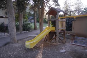 a playground with a yellow slide in a park at Kibbutz Beit Alfa Guest House in Bet Alfa