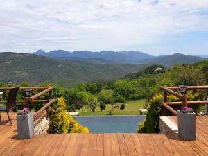 um deque com vista para uma piscina e para as montanhas em Hotel Rural & Spa Mas Prat em Vall de Bianya