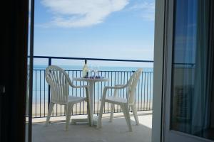 una mesa y sillas en un balcón con vistas al océano en Grand Hotel Excelsior, en Senigallia