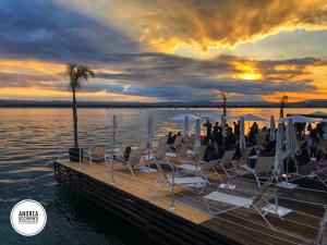 a group of people sitting in chairs on a dock at Isola Blu in Siracusa