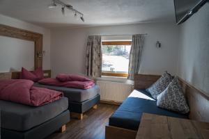 Zimmer mit 2 Betten, einem Sofa und einem Fenster in der Unterkunft Haus Almrausch in Sölden