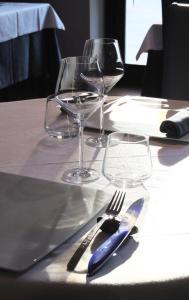 une table avec deux verres à vin et un couteau et une fourchette bleus dans l'établissement Auberge du Cellier, à Montner