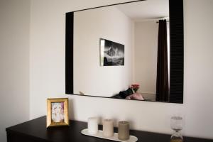 a mirror on a wall above a table with candles at Apartman JnJ Velkomoravska in Olomouc