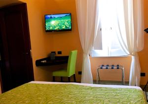 1 dormitorio con 1 cama y TV en la pared en Residenza Viviani en Sant'Agnello