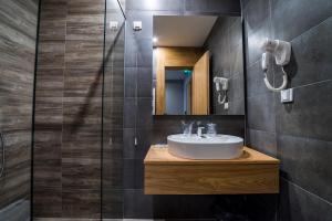 a bathroom with a sink and a mirror at Hotel Safir in Bihać