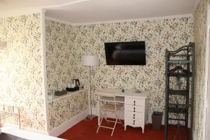 Habitación con escritorio y TV en la pared. en Manoir de Boisvillers, en Argenton-sur-Creuse
