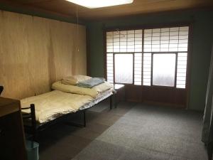 Habitación pequeña con 1 cama y 2 ventanas en Guesthouse Fuki Juku en Fuki